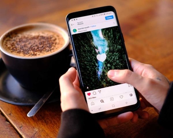 A person on a phone on instagram looking at advertising on instagram cost.