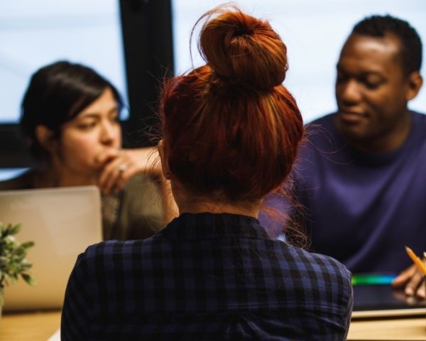 A group of people working on page social media on their laptops.