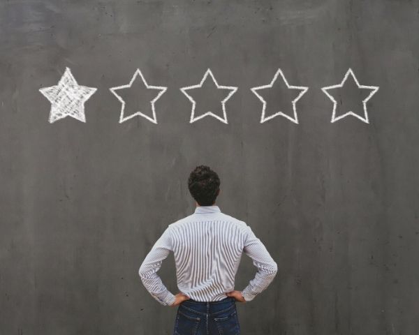A man staring at 1 star review due to bad social media agency services.