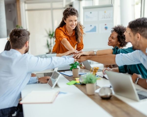 A team of seo agency usa employees putting their hands together for teamwork.