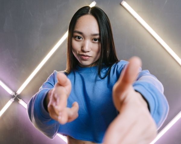 A woman doing funny finger shooting signs.