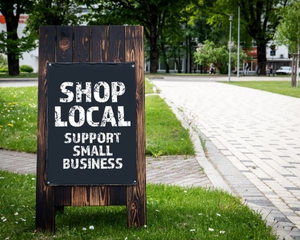 A sign saying "Shop local businesses".