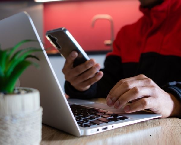 A media agency worker on his laptop and phone.