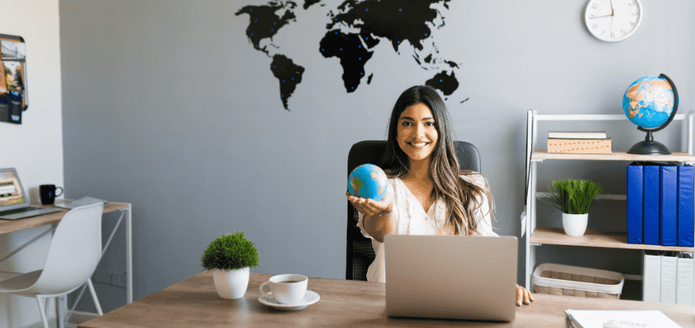 A lady of an ad agency holding a globe on her desk.