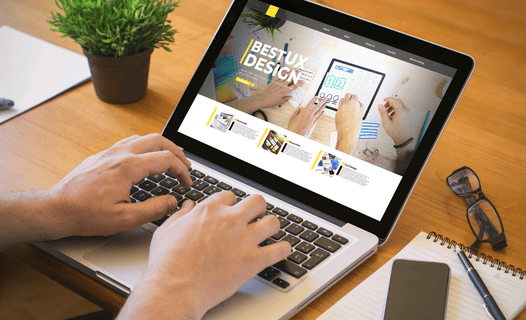A man working on web design services on his laptop.