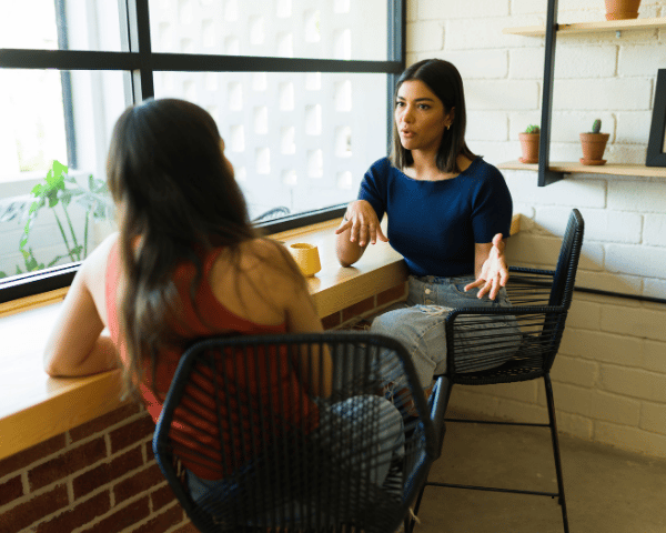 Two women talking at a coffee shop.